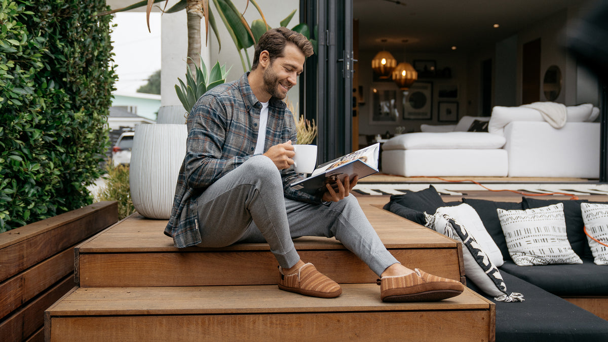Cobian Model reading a magazine and drinking coffee while wearing the Borrego Moccasin Tan #color_tan